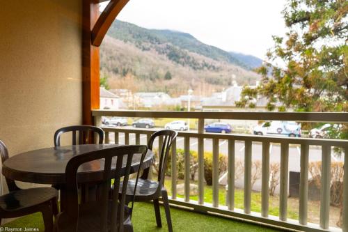 a table and chairs on a balcony with a view at Résidence Cami Réal **** in Saint-Lary-Soulan