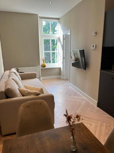 een woonkamer met een bank en een tv bij Old Town City Centre Apartment 2 in Nijmegen