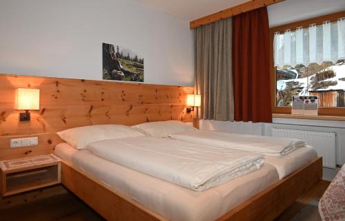ein großes Bett in einem Schlafzimmer mit Fenster in der Unterkunft Appartement Panorama NEU in Biberwier