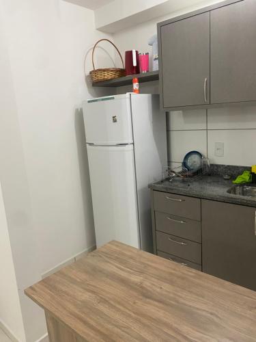uma cozinha com um frigorífico branco e um balcão em Quarto em Florianópolis em Florianópolis