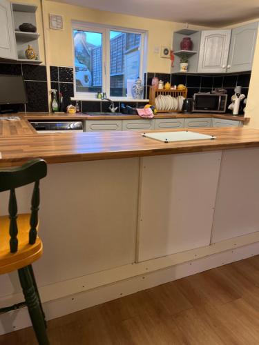 a kitchen with white cabinets and a wooden counter top at The Townhouse B and B in Aylesbury