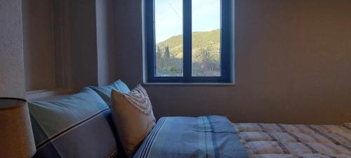 sypialnia z łóżkiem i oknem w obiekcie Κτήμα Μύλος (Κτήμα στη Φύση) w mieście Agrinio