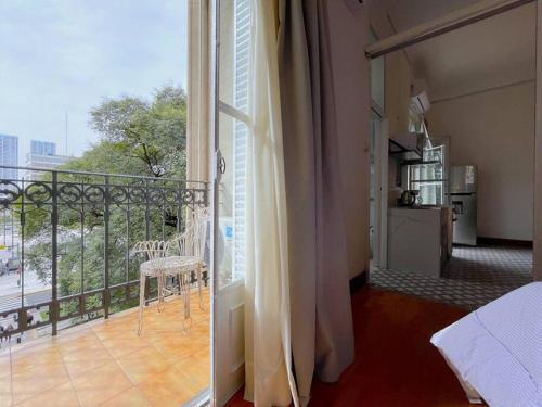a room with a balcony with a chair and a window at La Platea de Bs As [2A1] Live by the CCK. in Buenos Aires