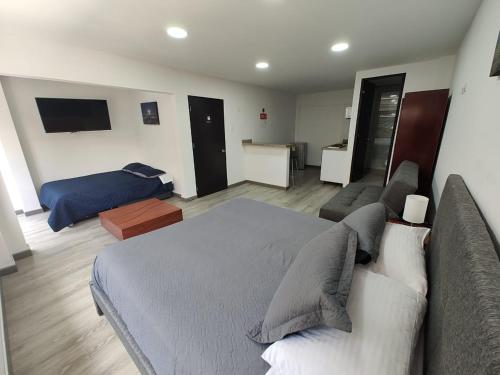 a bedroom with a large bed and a couch at HOTEL SALITRE STAR in Bogotá