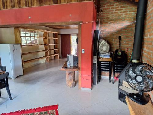 a room with a stove and a kitchen with a table at Aconchego da Beth in Camanducaia
