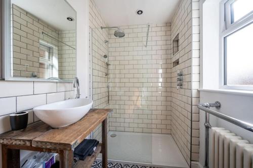 a bathroom with a white sink and a shower at Guest Homes - Sherrington Road Abode in Ipswich
