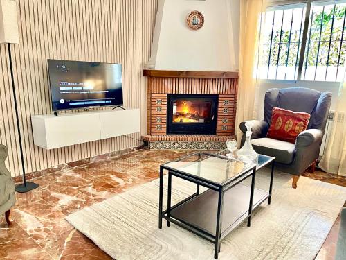 uma sala de estar com televisão e lareira em Casa rural Lomalinda em Granada
