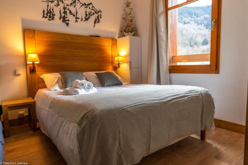 a bedroom with a large bed with a dog on it at Résidence Cami Réal **** in Saint-Lary-Soulan
