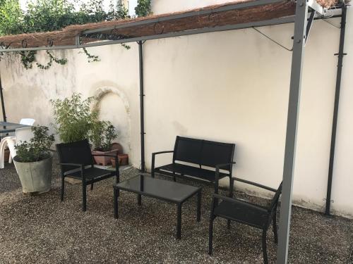 2 chaises et une table devant un mur blanc dans l'établissement Île madame, à Rochefort