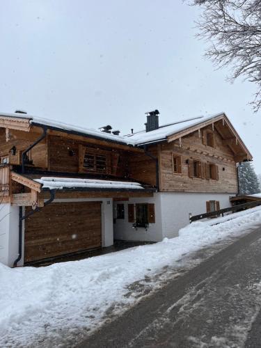 a house covered in snow with a snow covered driveway at Bergchalet Four Seasons in Reit im Winkl