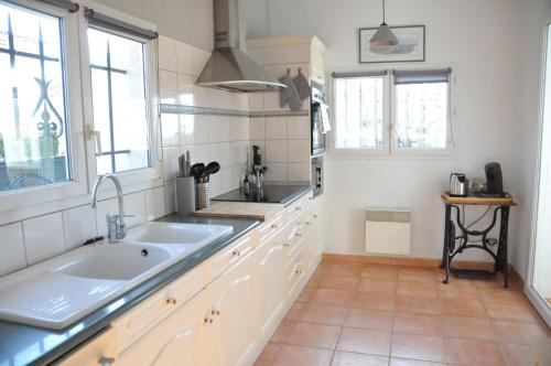 une cuisine avec un grand évier et une fenêtre dans l'établissement Les Nautiles, à Narbonne-Plage