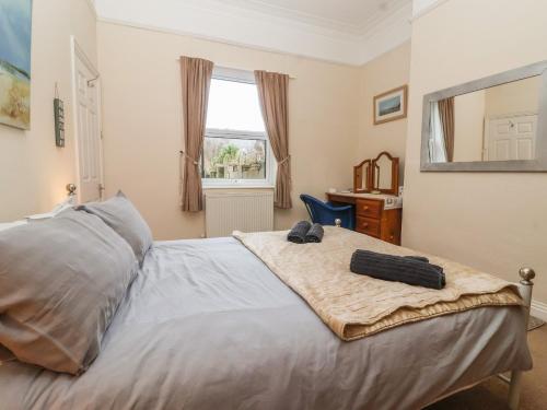 a bedroom with a bed with a mirror and a desk at Sea Front Apartment in Hornsea