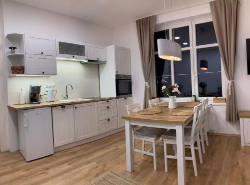 a kitchen with a wooden table and a dining room at Andy Apartmán Jáchymov in Jáchymov