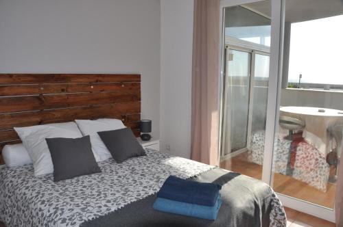 une chambre avec un lit avec une tête de lit en bois dans l'établissement Les Nautiles, à Narbonne-Plage