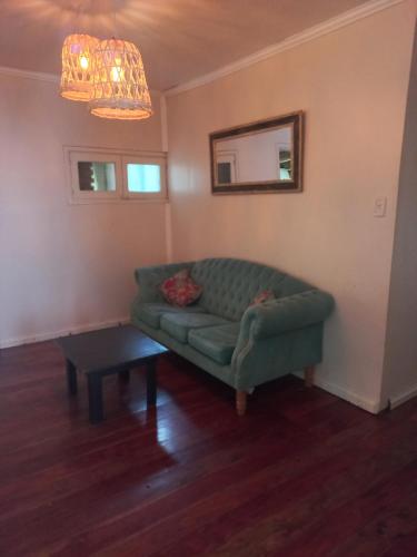 a living room with a green couch and a table at Casa de vacaciones in Dos de Mayo