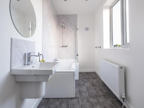 a white bathroom with a sink and a mirror at Ferry House - HUGE spacious home, FREE PARKING & WIFI in North Shields
