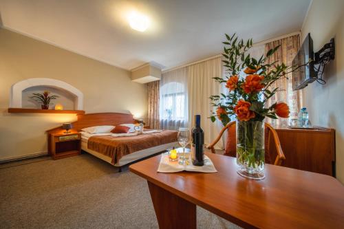 ein Hotelzimmer mit einer Blumenvase auf dem Tisch in der Unterkunft Hotel Gromada Toruń in Toruń