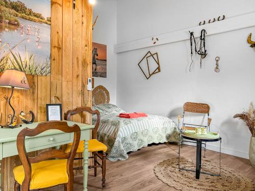 une chambre avec un lit, un bureau et une table dans l'établissement La Bergerie Douceur, à Aubord