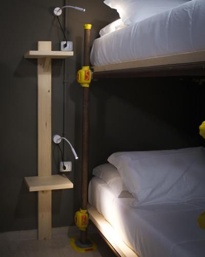a bedroom with a bunk bed with two lights on it at Hostelò - Luxury Hostel in Palermo