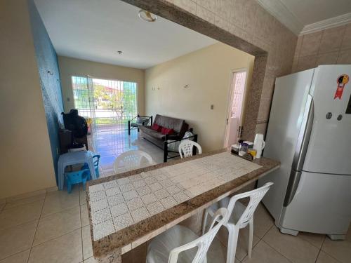 a kitchen with a refrigerator and a table and chairs at Apartamento Mobiliado cozinha completa na Praia in Salinópolis