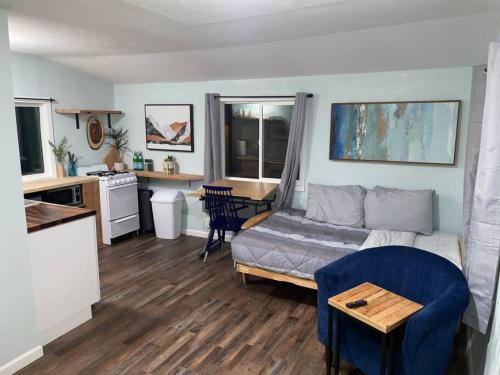 a living room with a couch and a kitchen at Cozy Little Cabin Slumber Village 3 in Anchorage