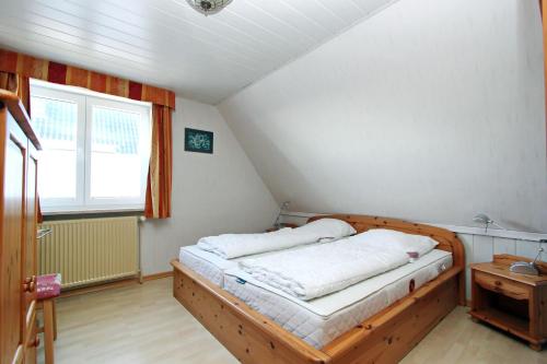 - une chambre avec un lit en bois et une fenêtre dans l'établissement App-West-ARH-132, à Westerland