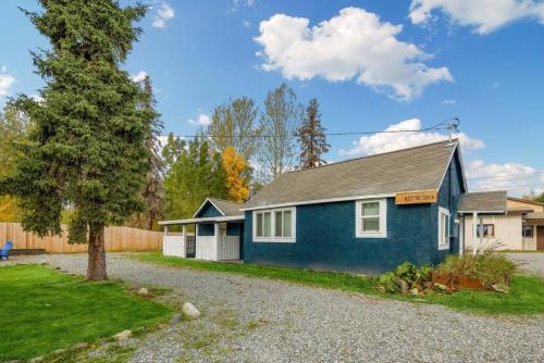 a blue house with a tree in the driveway at Charming Midtown Bungalow Slumber Village 2 in Anchorage