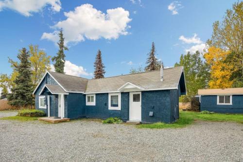 a blue and white house with a gravel driveway at Pendleton Cottage Slumber Village 1 in Anchorage