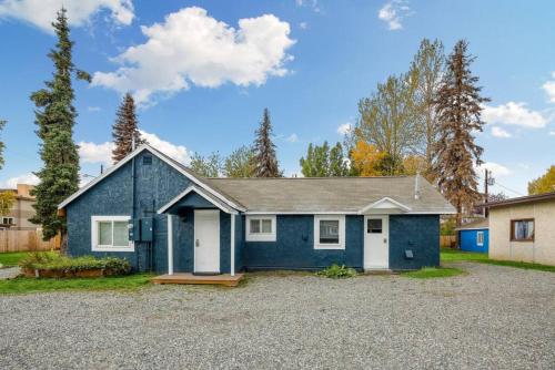 a blue house with a gravel driveway at Pendleton Cottage Slumber Village 1 in Anchorage