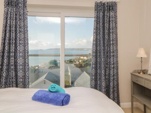 a bedroom with a bed and a large window at Looe Island View in Torpoint