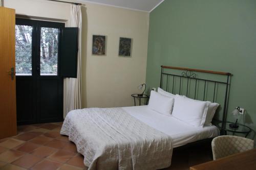 1 dormitorio con 1 cama con sábanas blancas y ventana en Casale Delle Arti, en Mosciano SantʼAngelo
