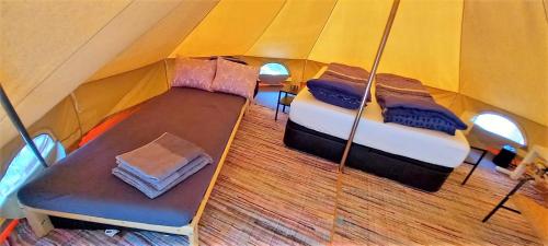Bell-tenten Quinta Pomar Do Pontido في كابيسيراس دى باستو: اطلالة علوية على خيمة بها سريرين ومقعد
