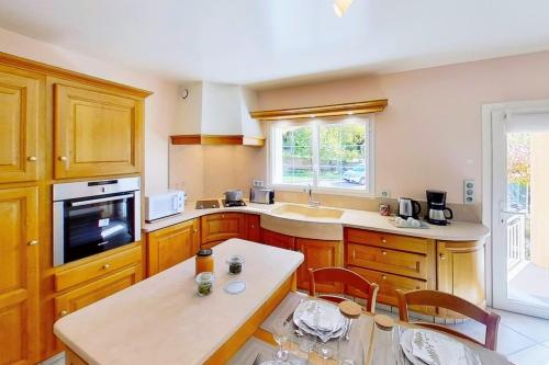 a kitchen with wooden cabinets and a table in it at CASA-Moissiere renovated 2 bedroom apartment in renovated sheepfold in La Bâtie-Neuve