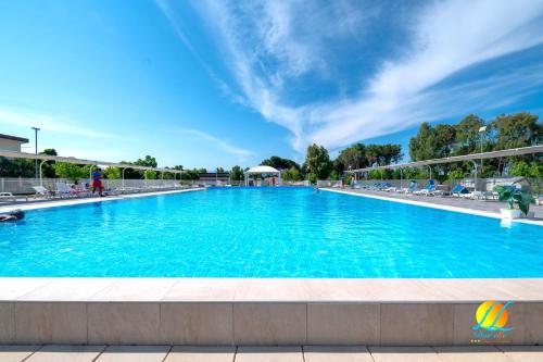 uma grande piscina com água azul em Village Due Elle em Marina di Schiavonea