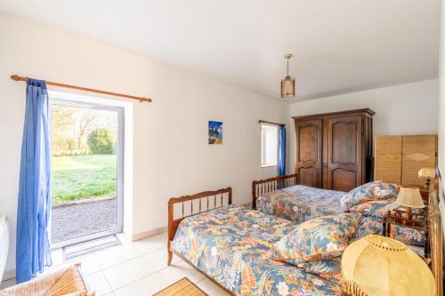 two beds in a room with a window at La clé des champs in Saint-Julien-des-Landes