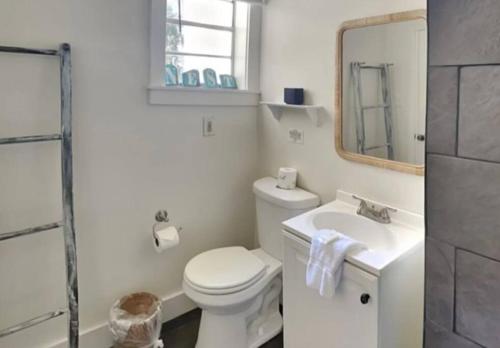 uma casa de banho com um WC, um lavatório e um espelho. em Harmony House em Savannah