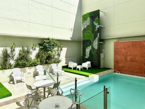 Un patio con mesas y sillas y una piscina. en Ayres Apartments Recoleta - Guido 1980, en Buenos Aires