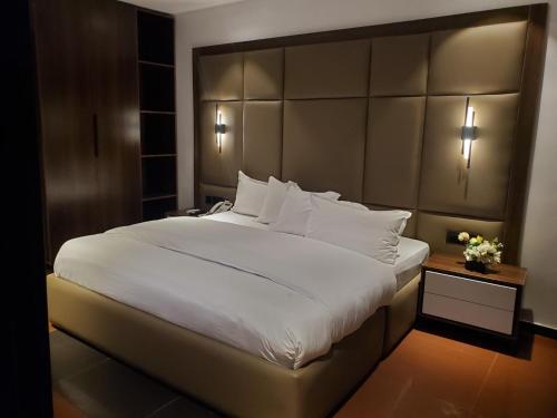 a bedroom with a large bed with a large headboard at Hotel Thirty Five in Lagos