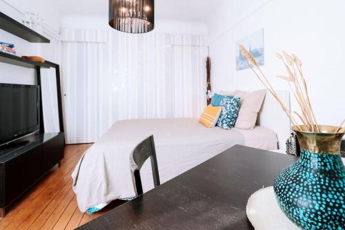 - un salon avec un lit et un vase sur une table dans l'établissement Paris Langeac Apartments, à Paris