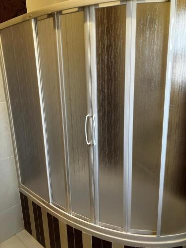 a shower stall with stainless steel doors in a bathroom at Sweet Home in Cairo