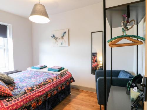 1 dormitorio con cama y espejo en 3 Sunnyside Terrace, en Matlock