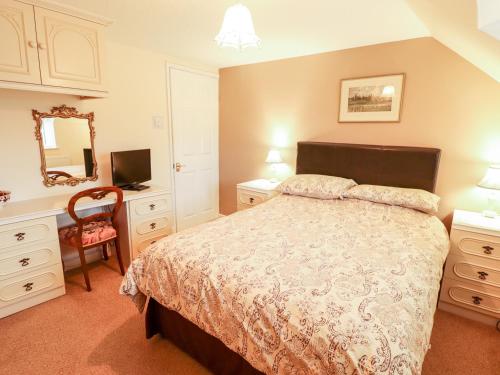 a bedroom with a bed and a mirror and a chair at 22 Beckside in Sudbrooke