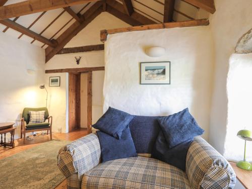 a living room with a couch and a chair at Pant y Crintach in Amlwch