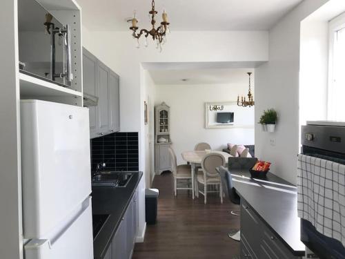 une cuisine avec des appareils électroménagers blancs et une salle à manger dans l'établissement Le Gîte En Chalet, à Garidech