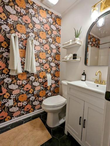 a bathroom with a toilet and a floral wallpaper at Bohemian Tiny Home - Walk to Starbucks in Taylors