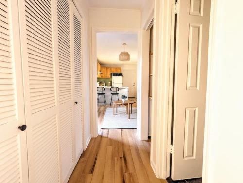 a hallway with white doors and a kitchen at Bohemian Tiny Home - Walk to Starbucks in Taylors