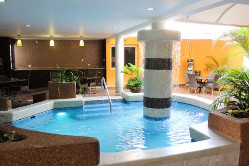 a swimming pool with a fountain in a building at Santa Fe Inn Hotel in Punto Fijo