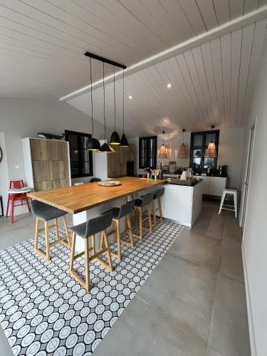 une grande cuisine avec une table et des chaises en bois dans l'établissement La villa Bremaudières - Villa pour 14 personnes avec Piscine à 150m de la mer, au Bois-Plage-en-Ré