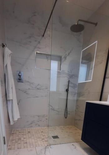 a shower with a glass door in a bathroom at Stunning Family Home Sleeps 10 in Dublin