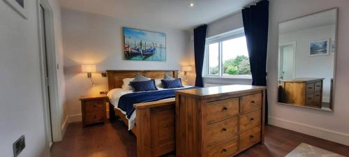 a bedroom with a bed with blue sheets and a window at Stunning Family Home Sleeps 10 in Dublin